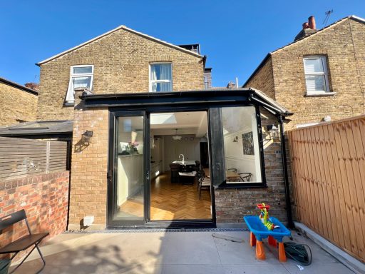 Side return extension. Ealing W13 Kitchen extension of Edwardian terrace in Ealing W13 with large glass doors and a small outdoor area.