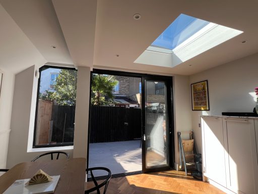 Kitchen extension skylight and large patio doors Inside kitchen extension with large windows, skylight, and a view of an outdoor space.